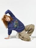 Model posing in a blue Hallstatt Austria sweatshirt with khaki cargo pants.