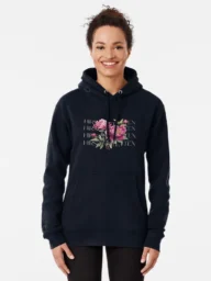 Smiling woman wearing a black hoodie with a floral design and 'Hirschtetten Vienna' text, representing casual fashion inspired by Hirschtetten, Vienna.