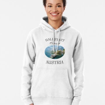 Female model wearing a white Hallstatt-themed hoodie, front view