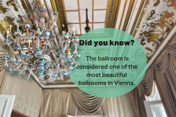 A grand chandelier hanging in the Otto Wagner Villa’s ballroom, considered one of the most beautiful ballrooms in Vienna, with ornate ceiling and draped curtains adding to the elegance.