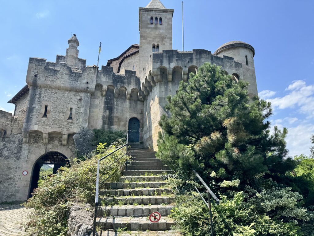 Close-up view of Burg Lichtenstein’s stone tower and medieval architecture under a clear blue sky.