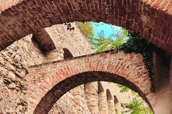 Close-up view of multiple brick archways on Eichelhofstraße, Vienna, with greenery.